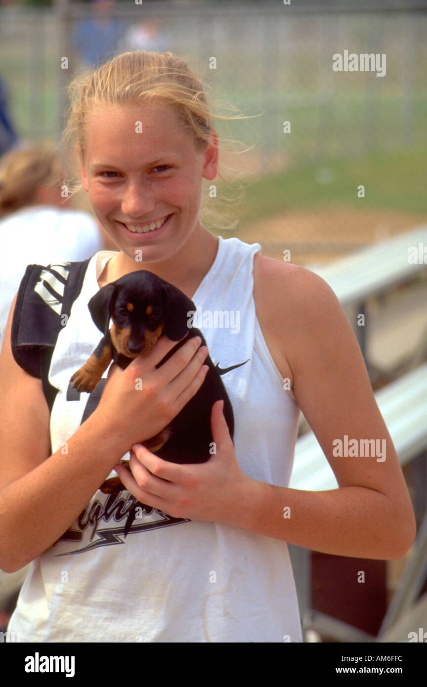 Fast pitch softball player age 18 holding puppy at Dunning Park. St