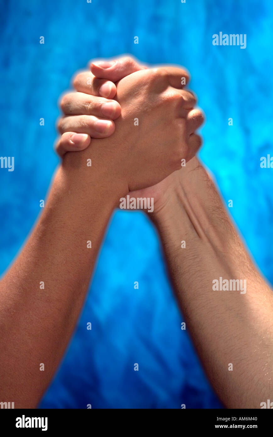 Brown hand and white hand clasped together for arm wrestling competition Stock Photo