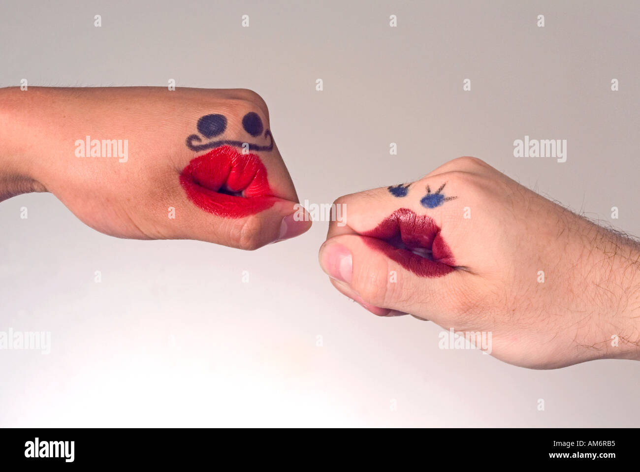 Hands with funny faces drawn on with lipstick Stock Photo