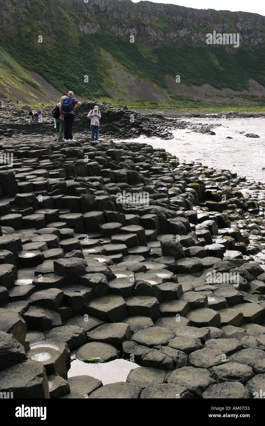 Visitors admire the sweeping coastal views at popular Northern Ireland tourist attraction the Giants Causeway Co Antrim NI Stock Photo