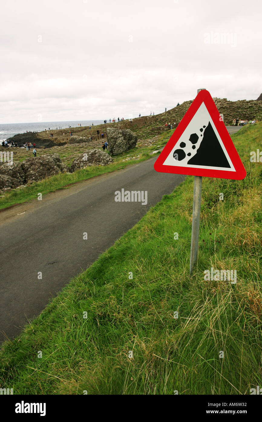 Ironic rock fall danger warning sign at foot of cliffs near the Giants Causeway, Antrim coast Northern Ireland GB Britain Stock Photo