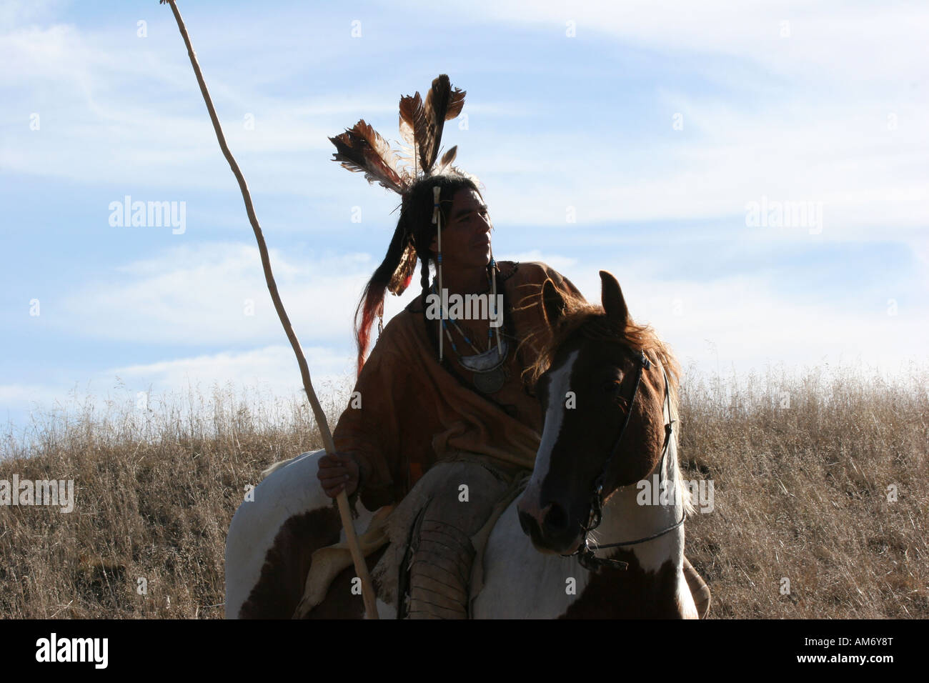 A Native American Indian man siting bareback on a horse riding the prairie of South Dakota Stock Photo