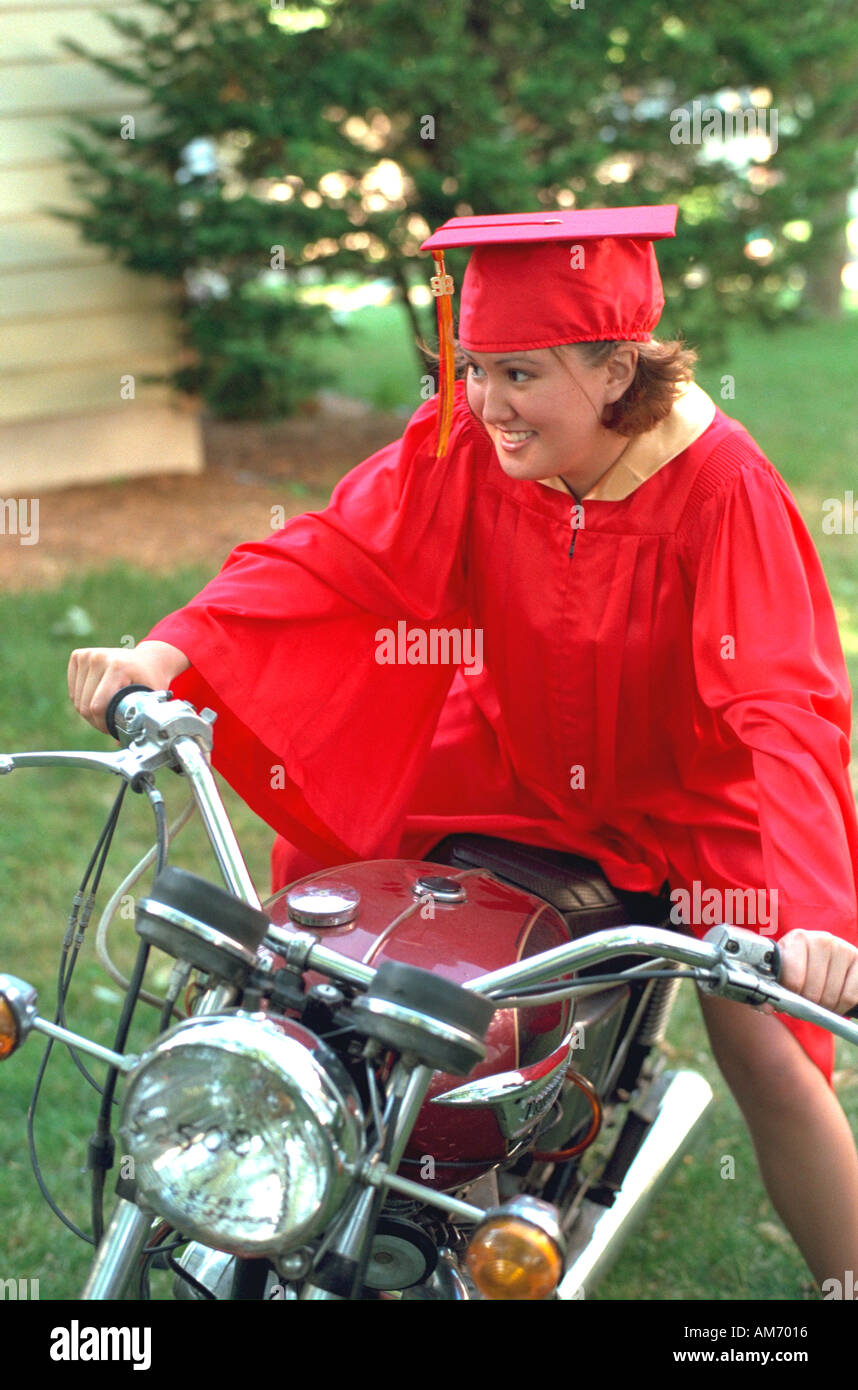 Graduate in red cap and gown age 18 sitting on her motorcycle. Elkhart