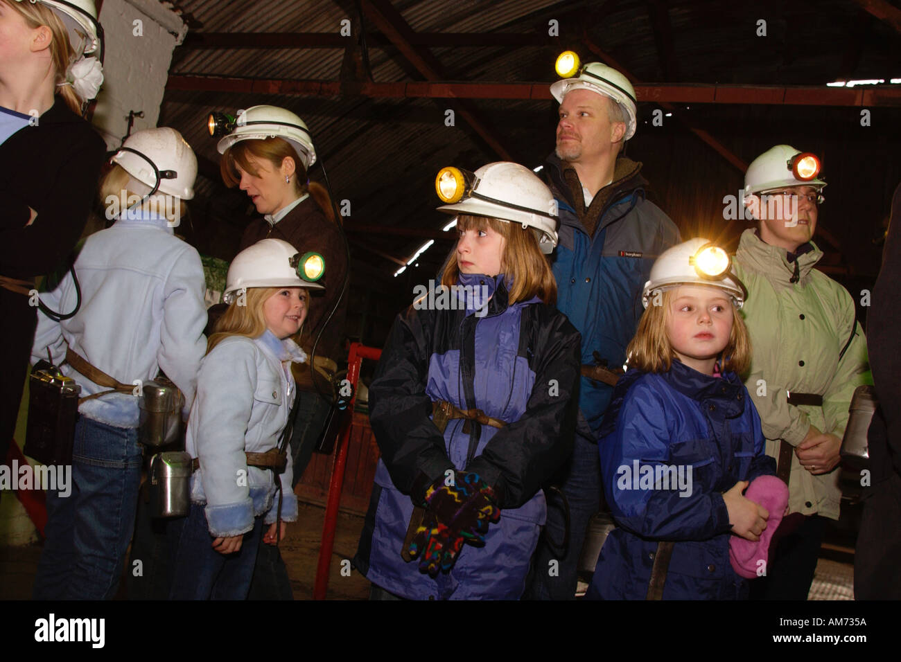 Visitors fitted with lamps and hard hats prepare to go underground at