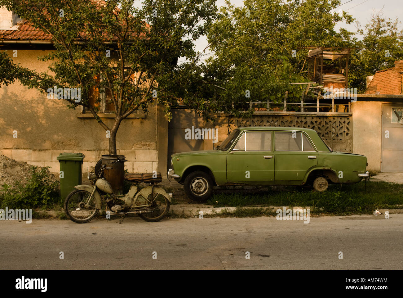 Old Lada and two-stroke moped in a street in Ivanovo, Romania Stock Photo