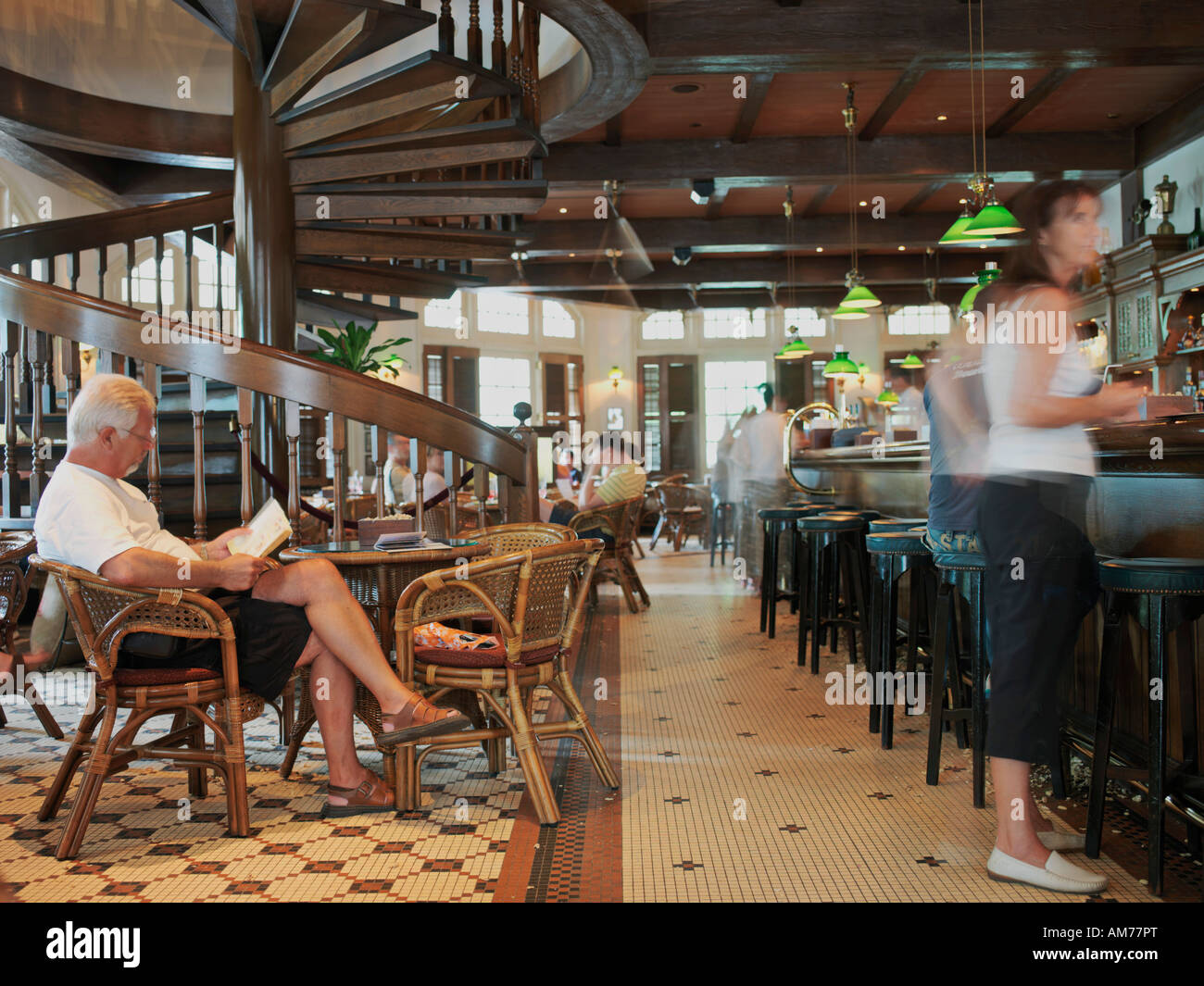 Patrons in the long bar of Singapore a famous bar situated in the Raffles Hotel Stock Photo