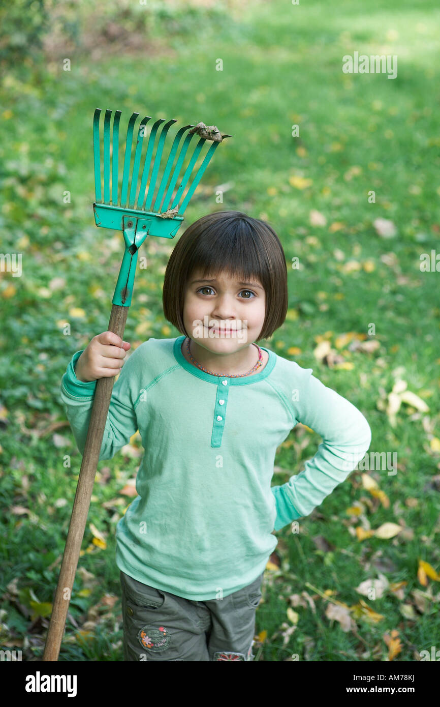 5 year old girl holding small rake Stock Photo - Alamy