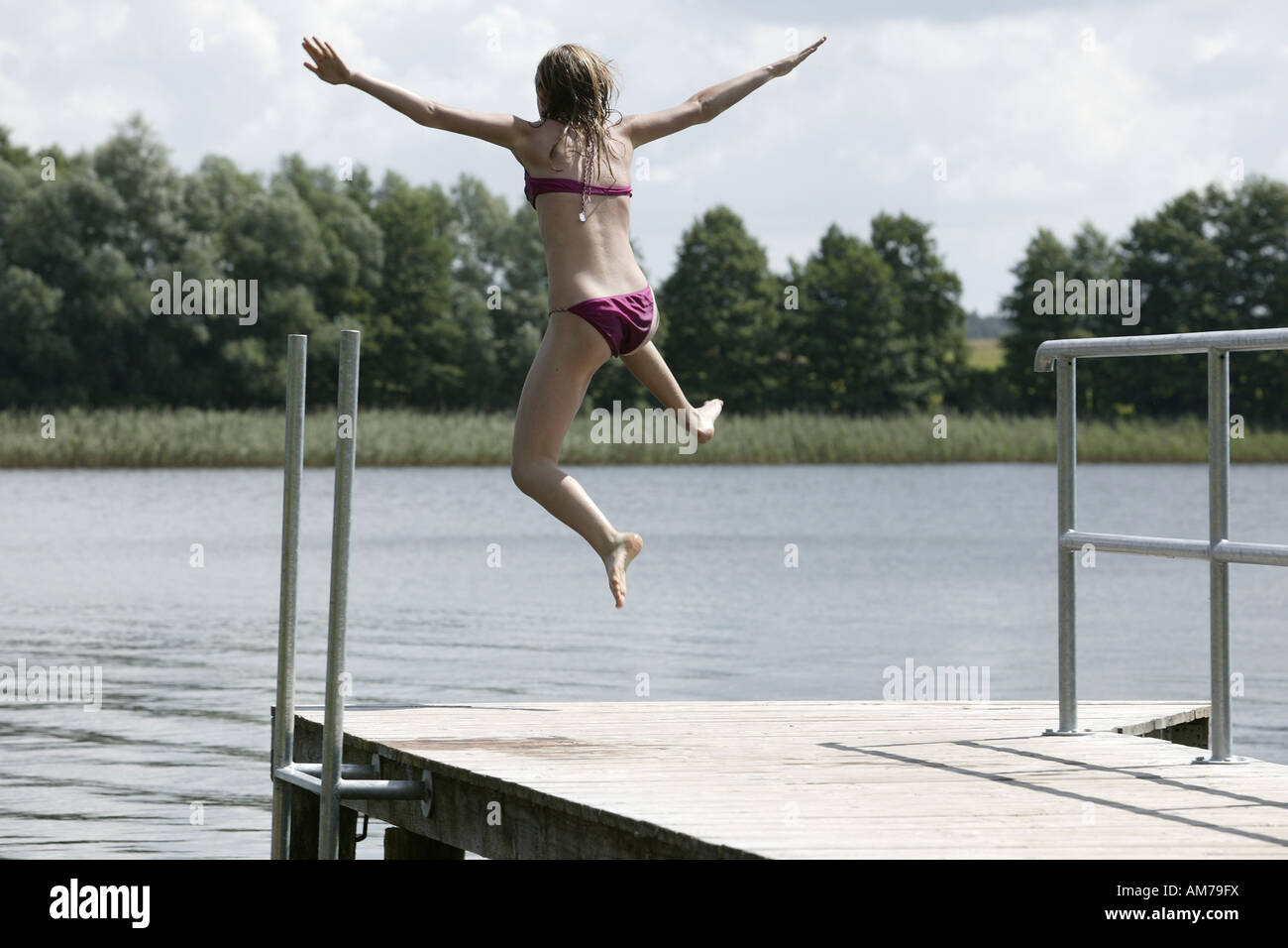 14 year old girl jumping into a lake Stock Photo