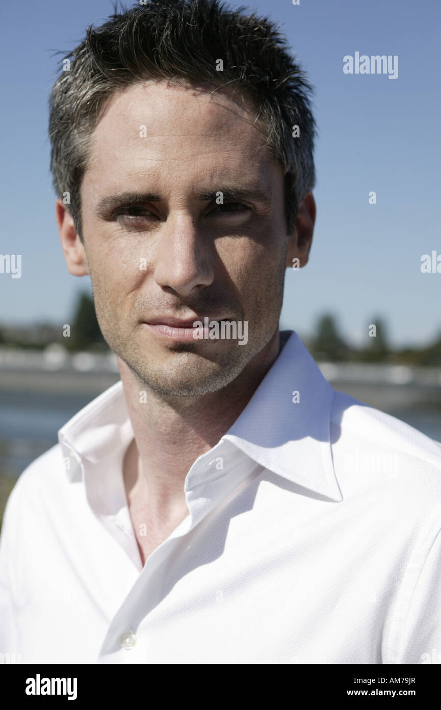 Portrait of a young man in white shirt at the riverside Stock Photo - Alamy
