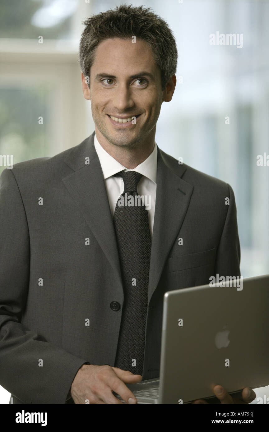 Business man with laptop in the lobby smiling Stock Photo