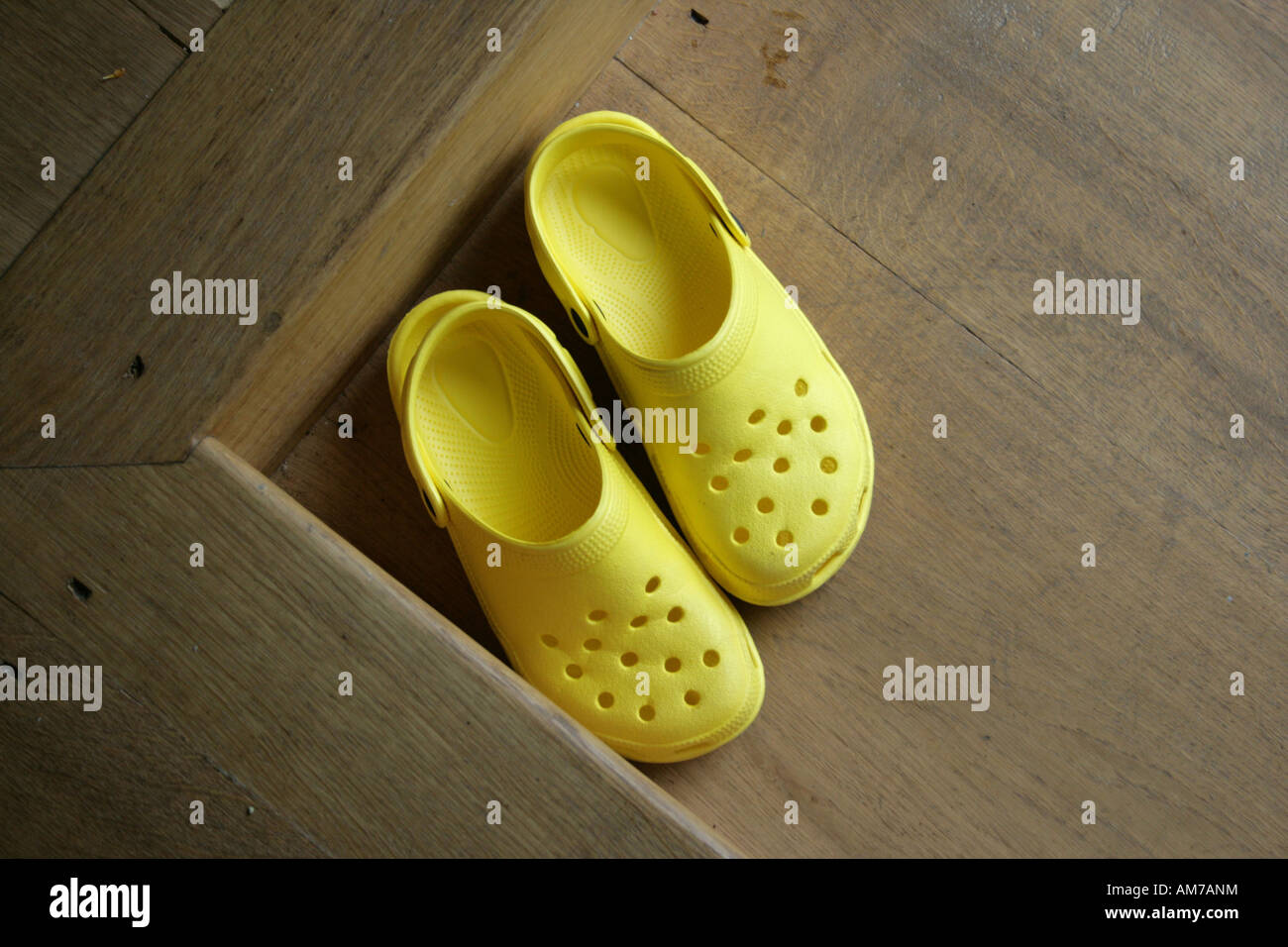 Crocs on wooden floor Stock Photo - Alamy