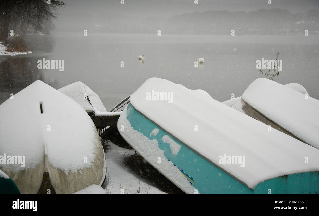 Snow covered boats by the side of a lake Stock Photo - Alamy