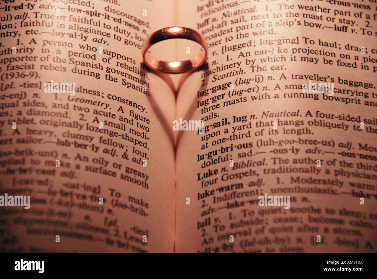 Heart shadow in book with ring Love dictionary Stock Photo