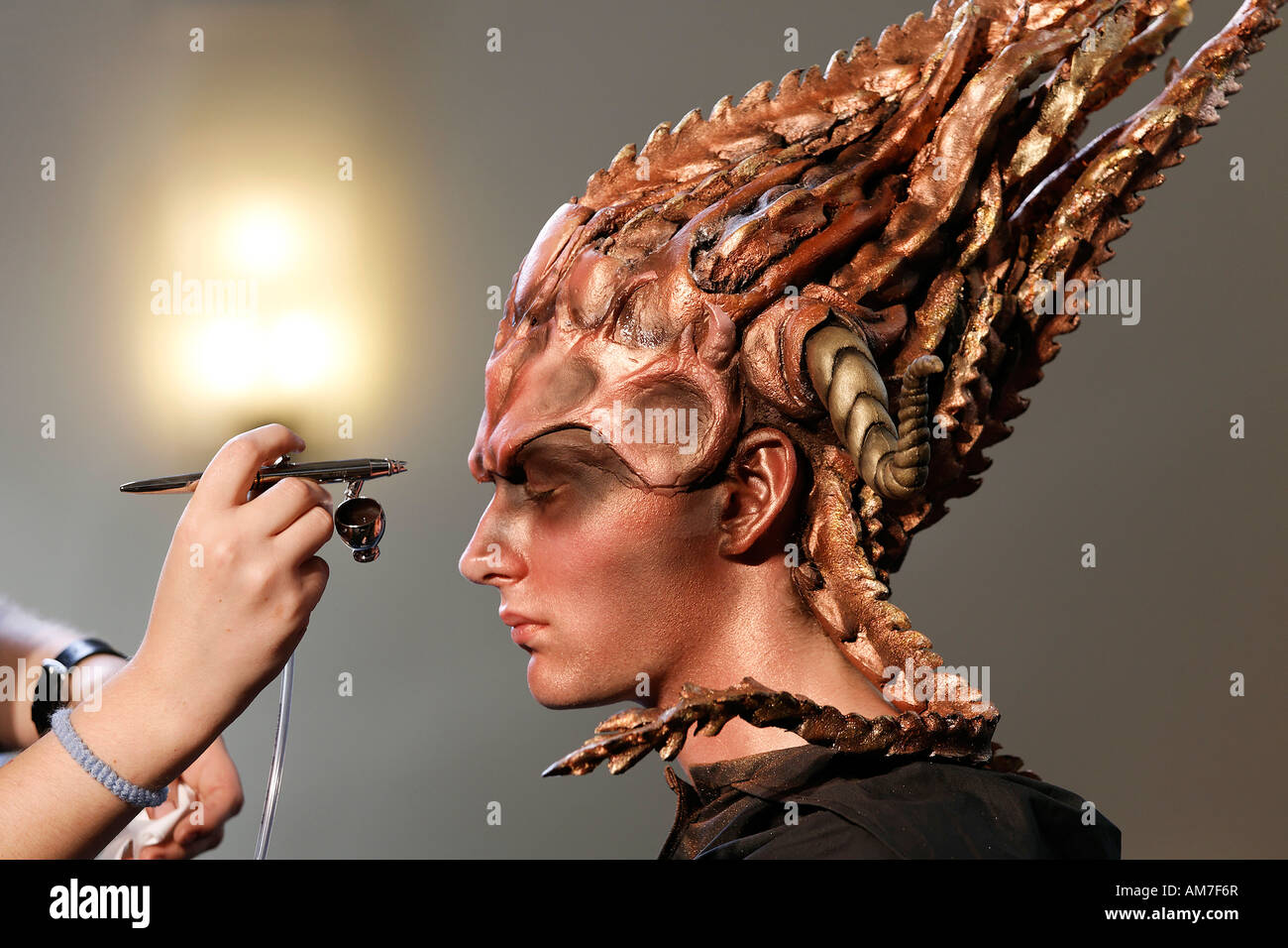 Surrealistic made up young man with mask is being sprayed with colour, bodypainting presentation, German Opera at the Rhine, Du Stock Photo