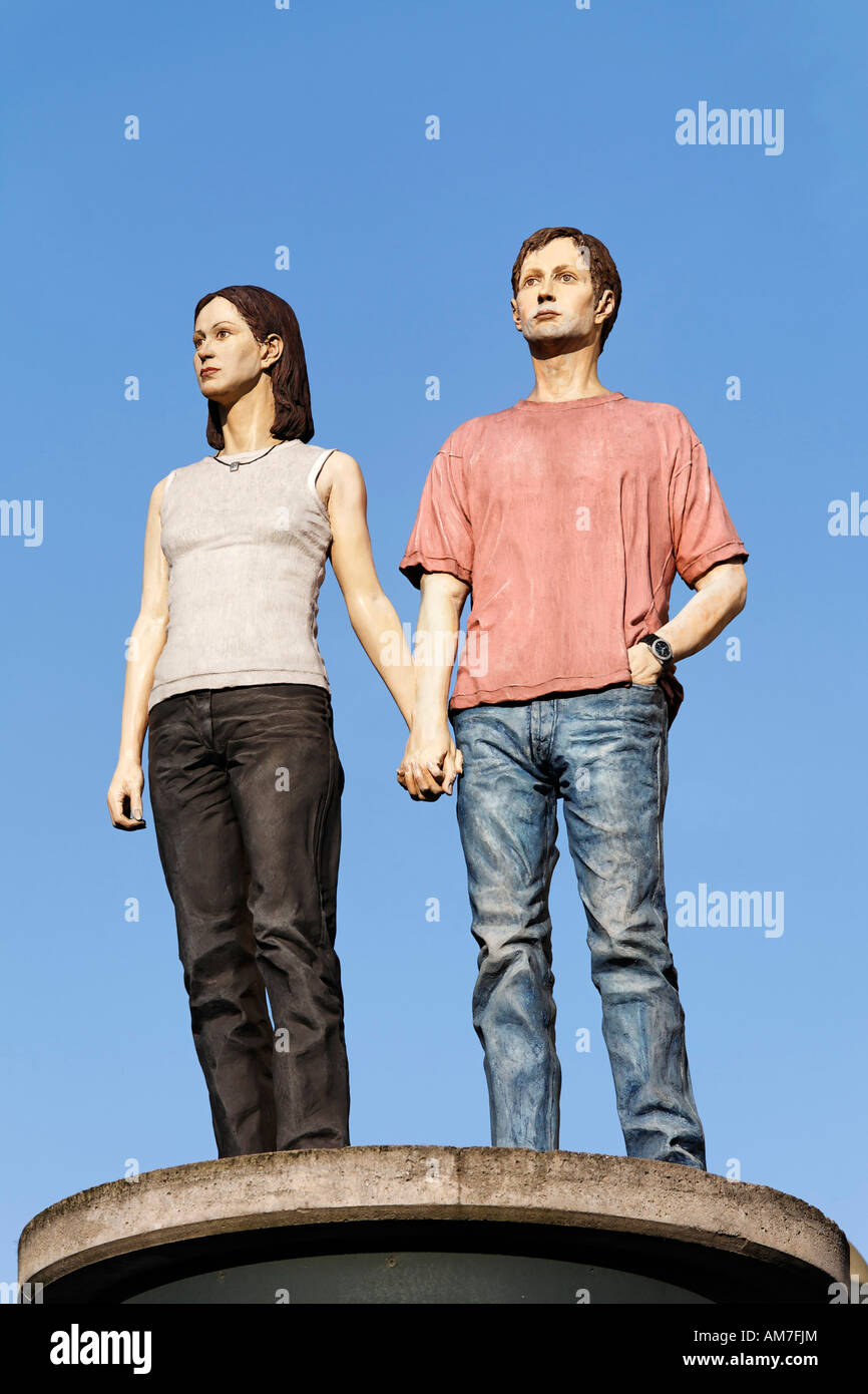 Young couple holding hands, sculpture standing at the top of a advertising column, Duesseldorf, NRW, Germany Stock Photo