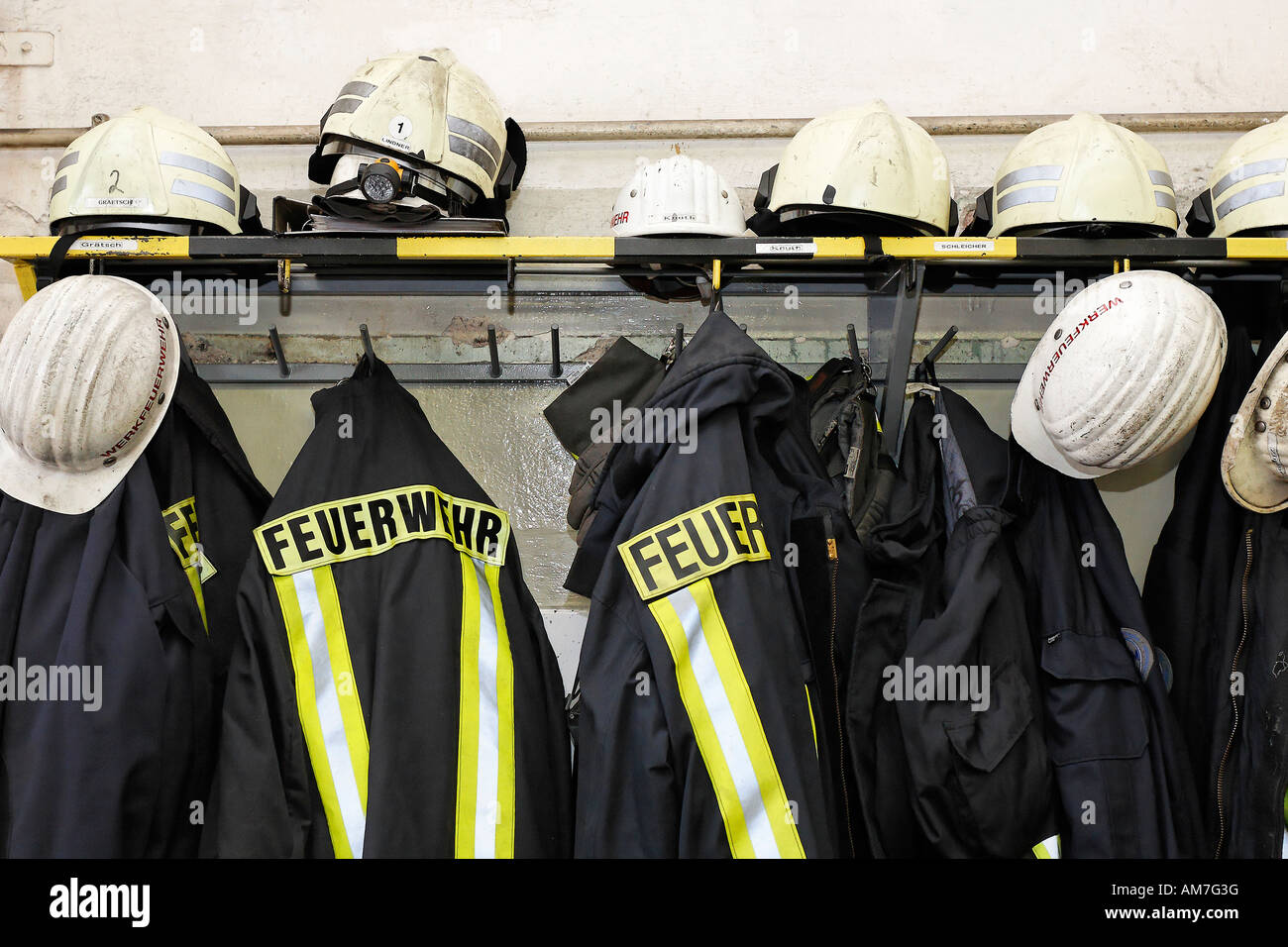 Coats and helmets of fire fighters at the men's quarter, Germany Stock Photo