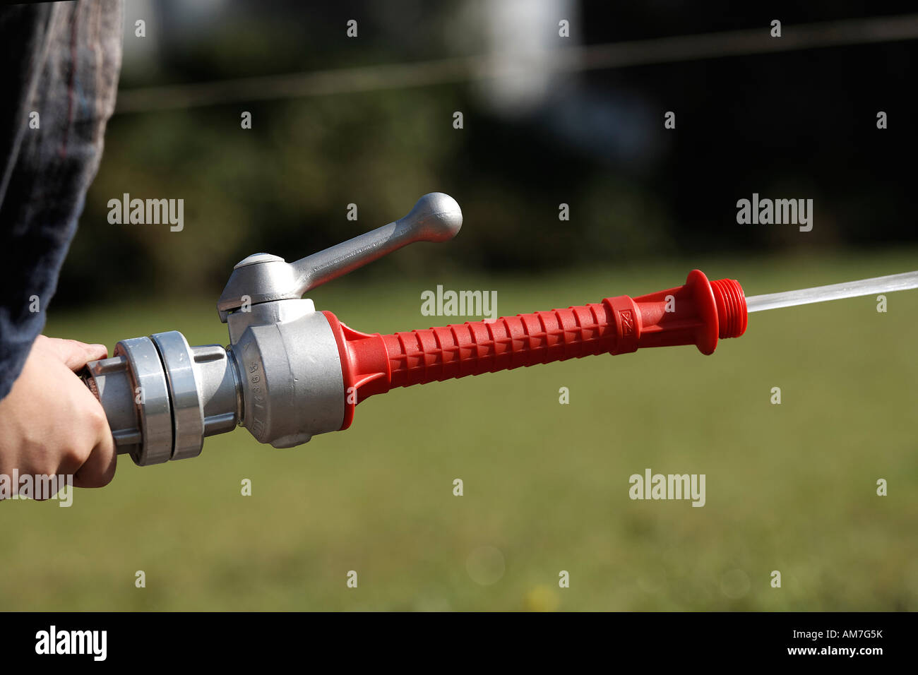 Hand of a child spraying with hose of the fire brigade, Germany Stock Photo