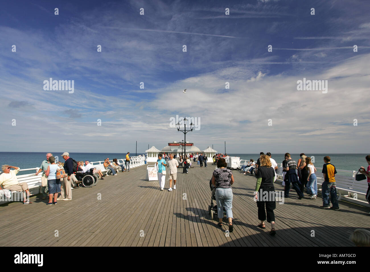 Tourists stroll down the restored wooden Pier boards of popular seaside town Cromer North Norfolk coast, East Anglia England UK Stock Photo