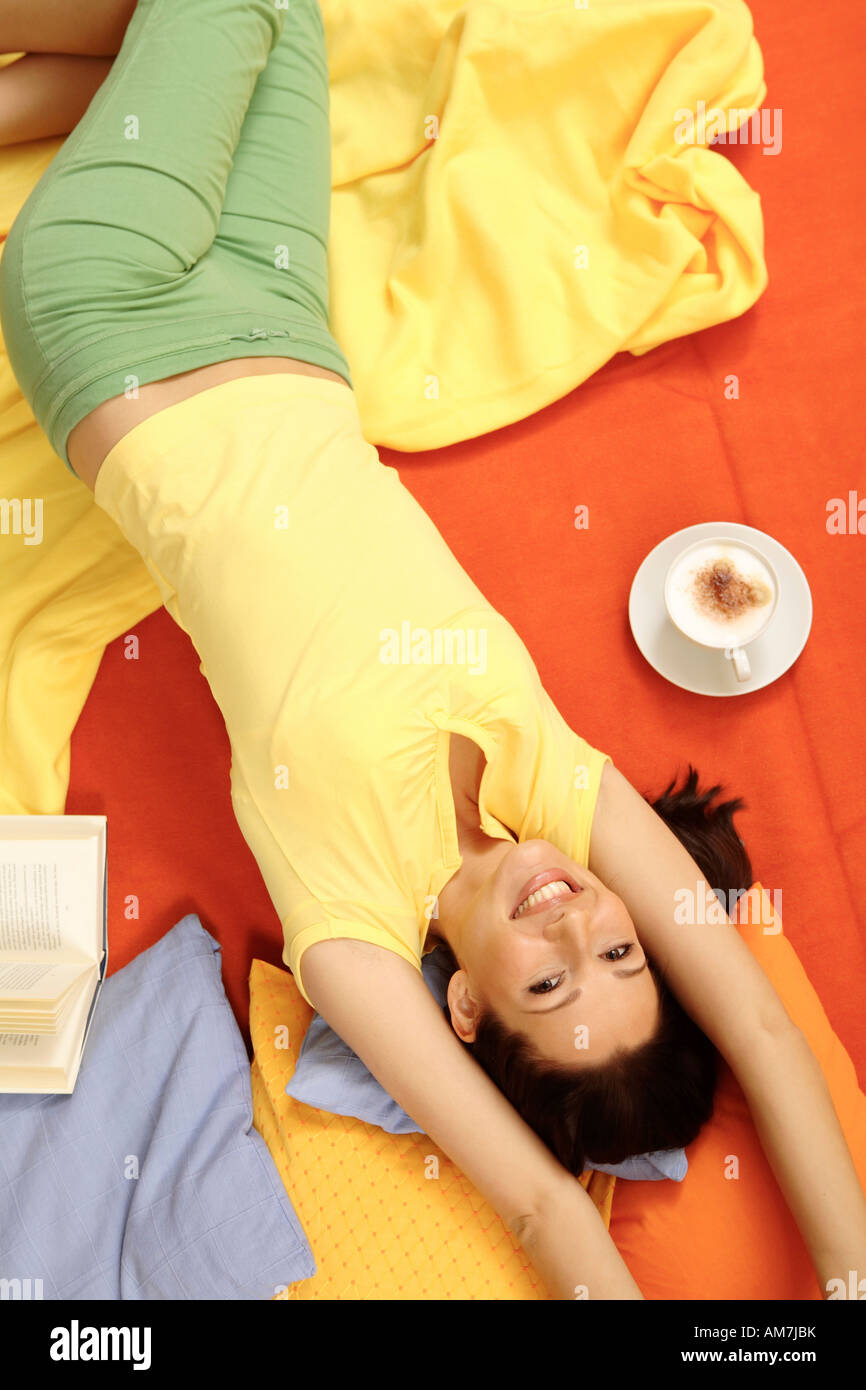 Young woman relaxing on pillows Stock Photo