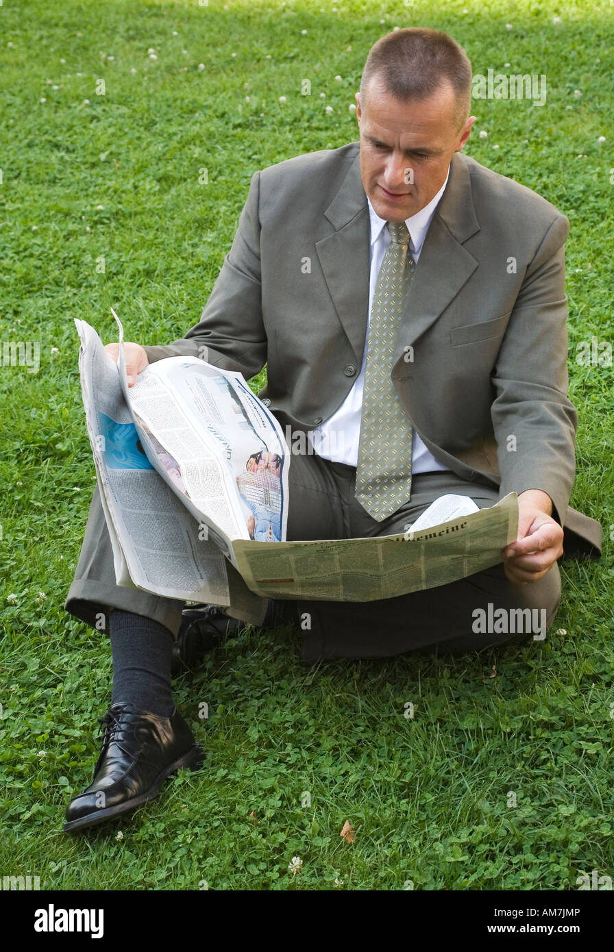 Businessman reading a paper during lunch break Stock Photo