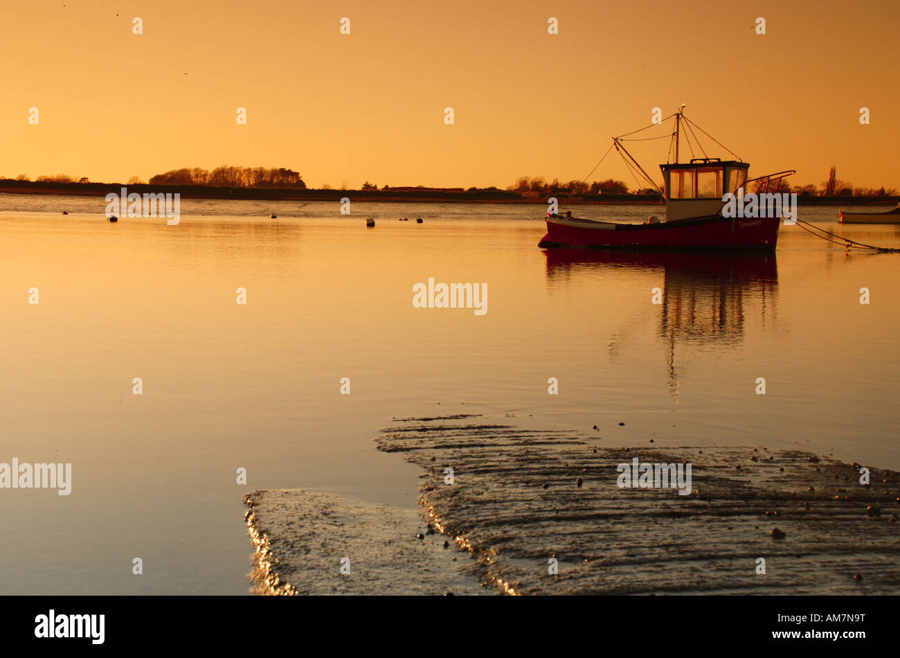 Small fishing boat at sunset Stock Photo