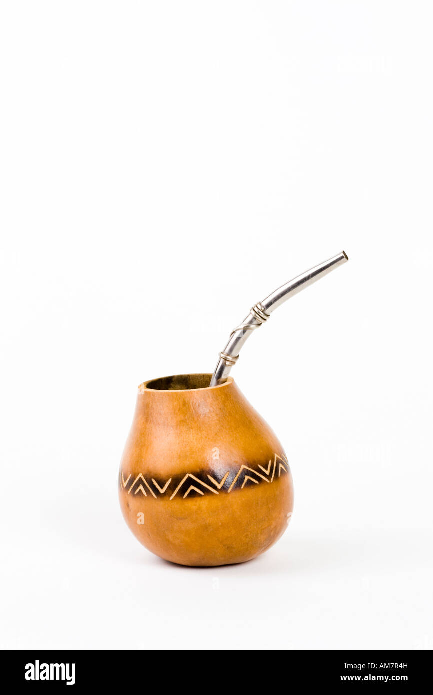 A mate cup with a metal straw place in front of a white background