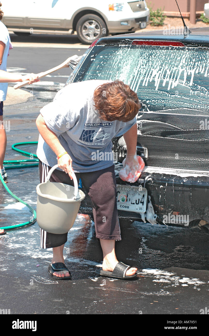 Teen church group has a donation car wash to help victims of Hurricane in Gulf Coast of USA, real kids having fun being community helpful needy real Stock Photo
