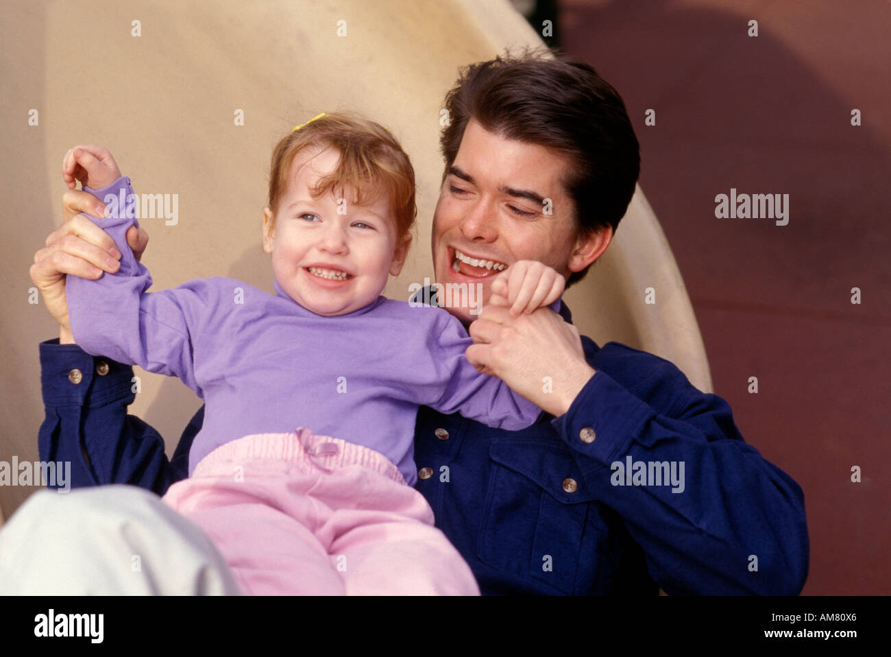 Young man playing with little girl [2, 3], smiling Stock Photo