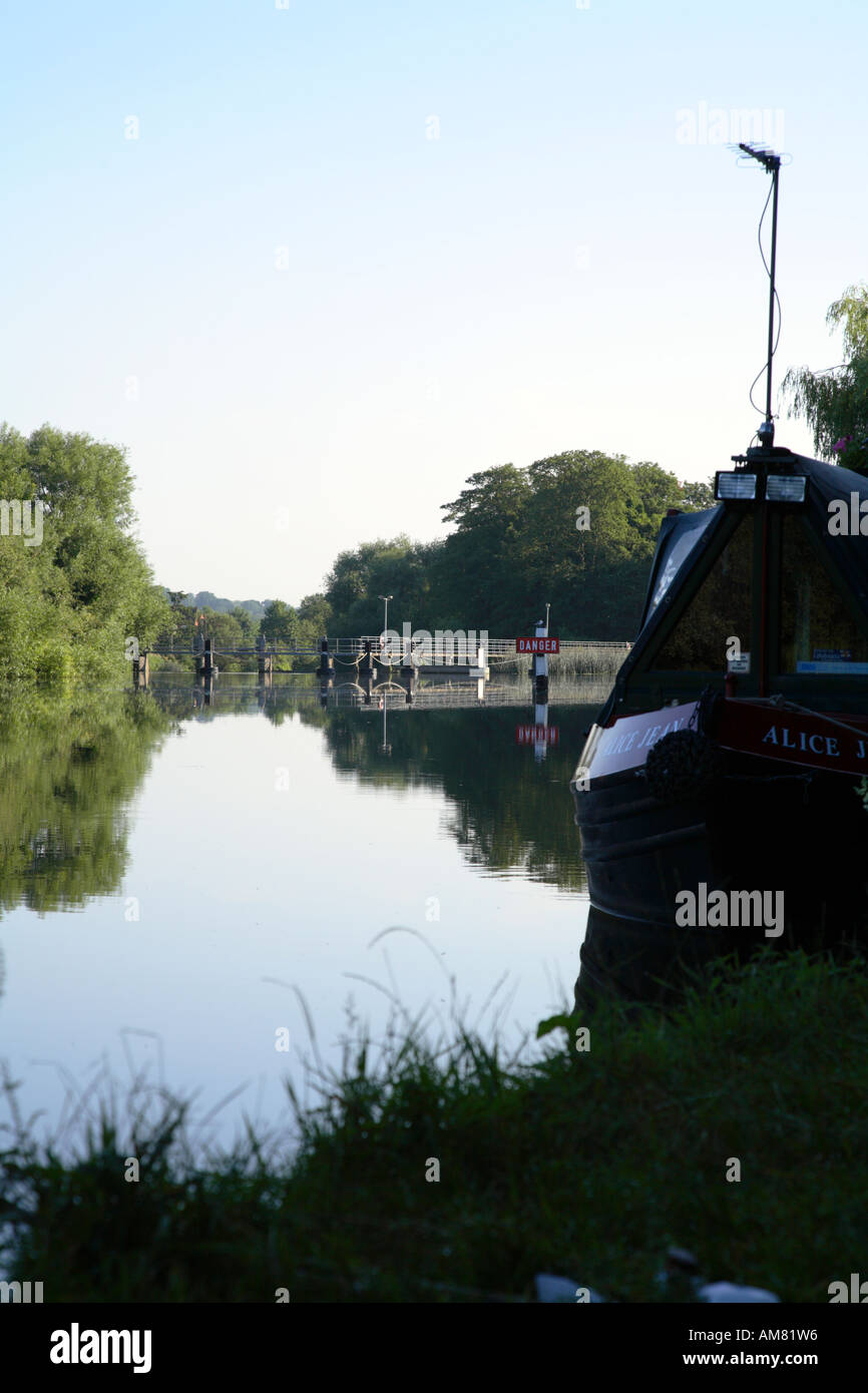 View of Sonning weir on river Thames from Thames path through moored barges 2 Stock Photo