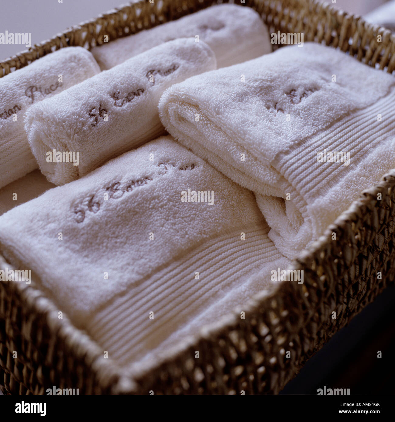 Folded white towels in a wicker basket Stock Photo