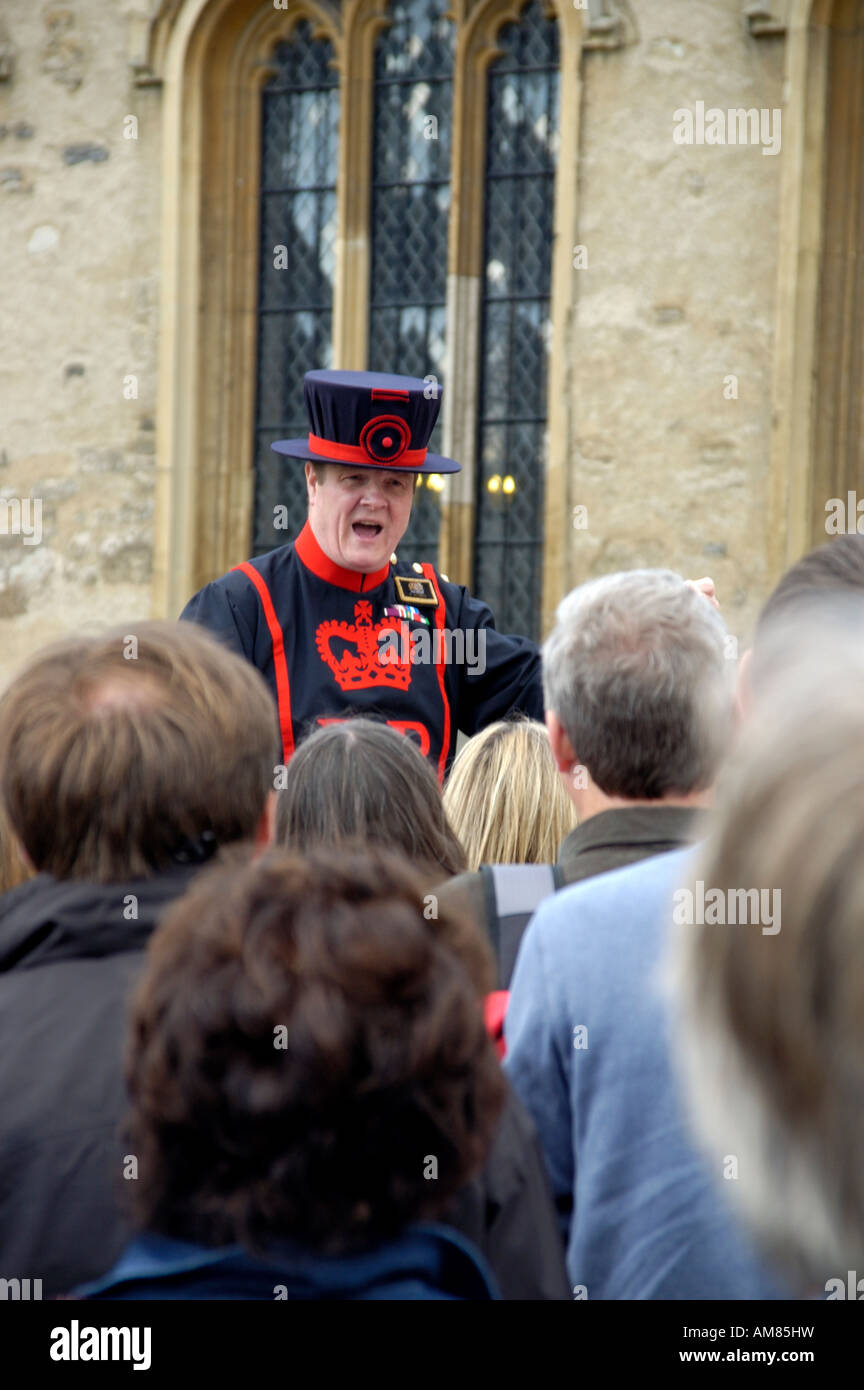 A Beefeater addresses a crowd of tourists at the Tower of London Stock Photo