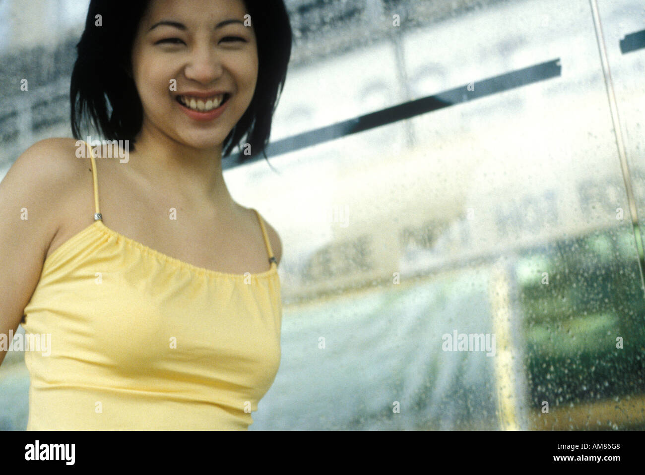 Young woman wearing yellow top, smiling, portrait Stock Photo - Alamy
