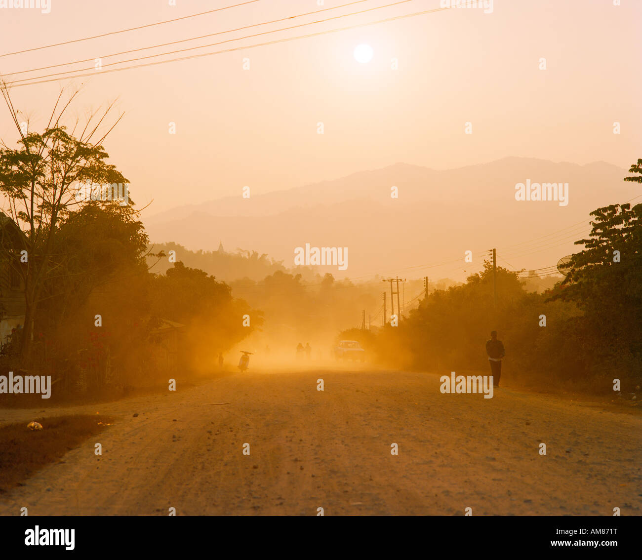 dusty road in the evening light in Oudomxay Laos Stock Photo