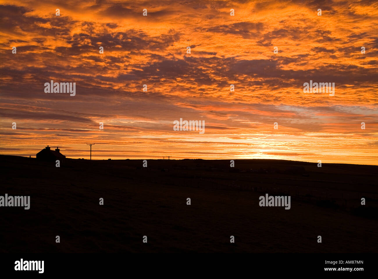 dh  ORPHIR ORKNEY Cottage silhouette and cloudscape sunset sky scottish croft fiery dusk orange clear red clouds highlands house uk scotland Stock Photo