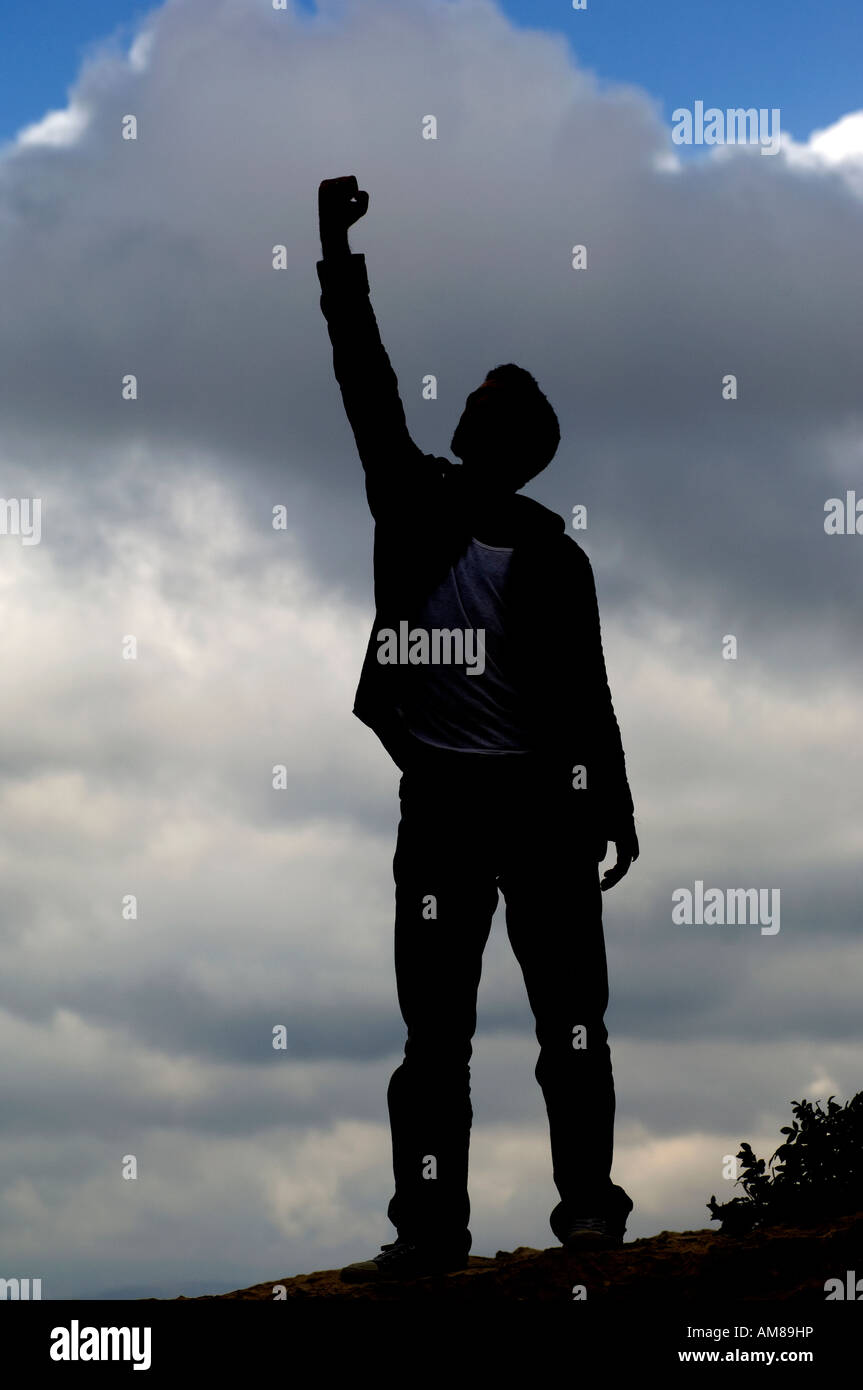 Silhouette of a young man hands up on top of a mountain Stock Photo - Alamy
