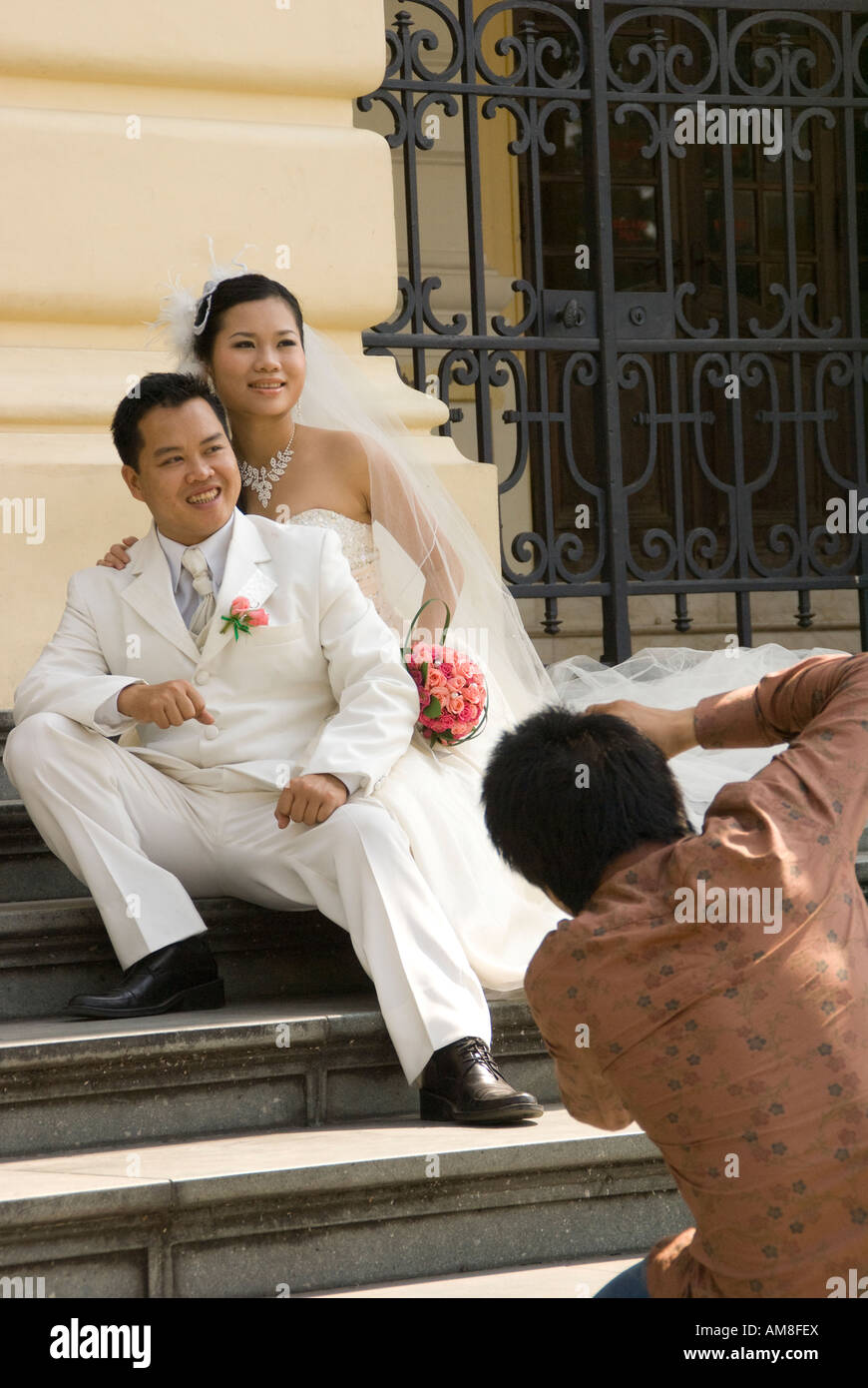 Bride and groom pose for wedding photos on steps of French colonial Hanoi Opera House Stock Photo