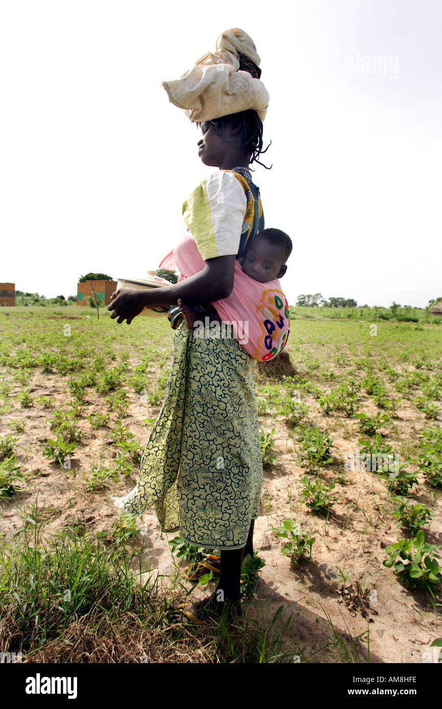 Fada N Gourma Burkina Faso August 23rd 2005 An Oue mother with her baby in a sling on her back Stock Photo