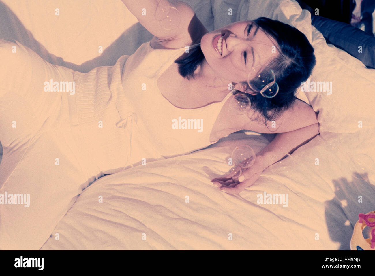 Young woman lying on bed Stock Photo