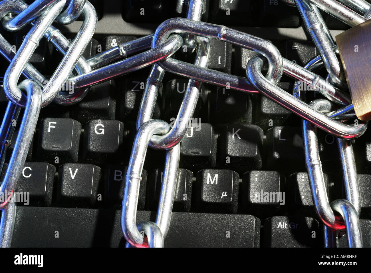 DEU, Germany : Symbolic photo, Internet and computer security. Computer keyboard with steel chain and lock Stock Photo