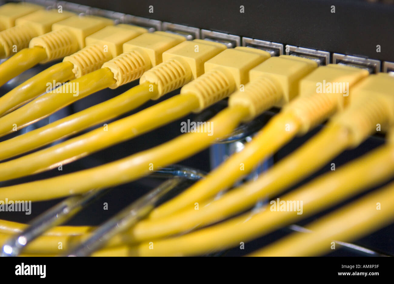 yellow ethernet cables connect black ethernet hubs Stock Photo