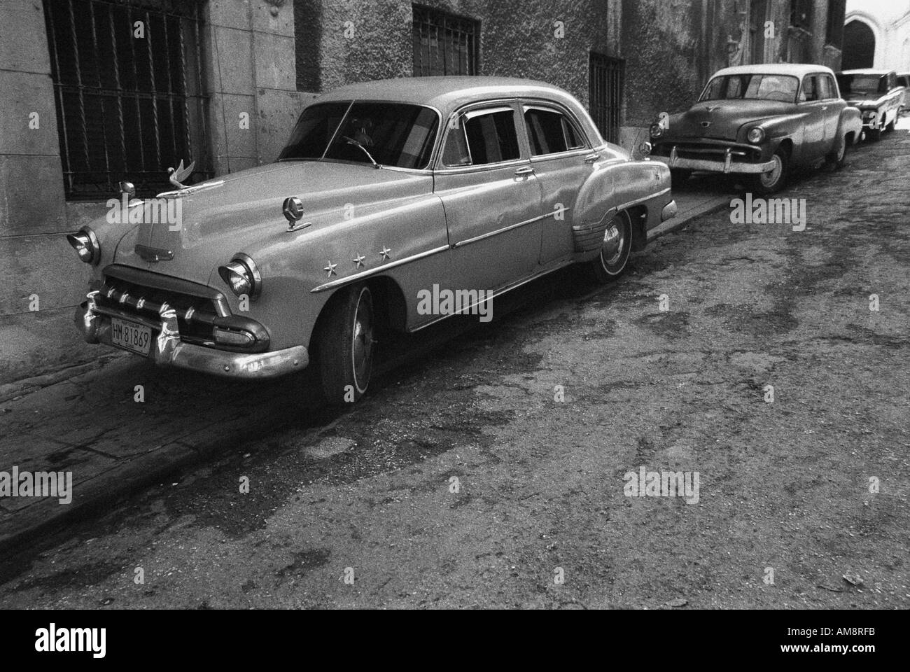 Old battered rusty Cadillac Limo Scene in a street in old Havana near the Cathedral Reportage shot Shot belongs to a series of Stock Photo