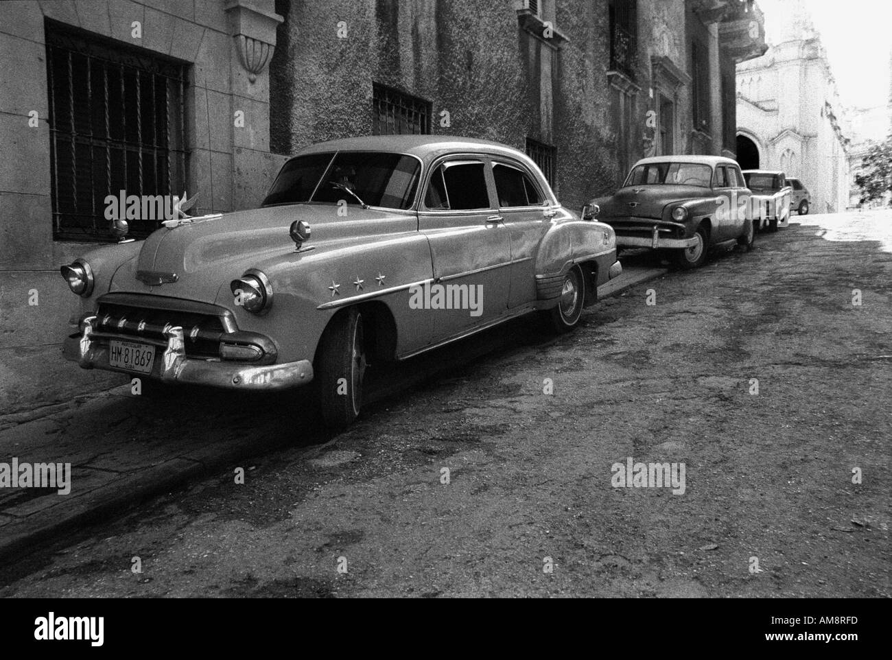 Old battered rusty Cadillac Limo Scene in a street in old Havanna near the Cathedral Reportage shot Shot belongs to a series of Stock Photo