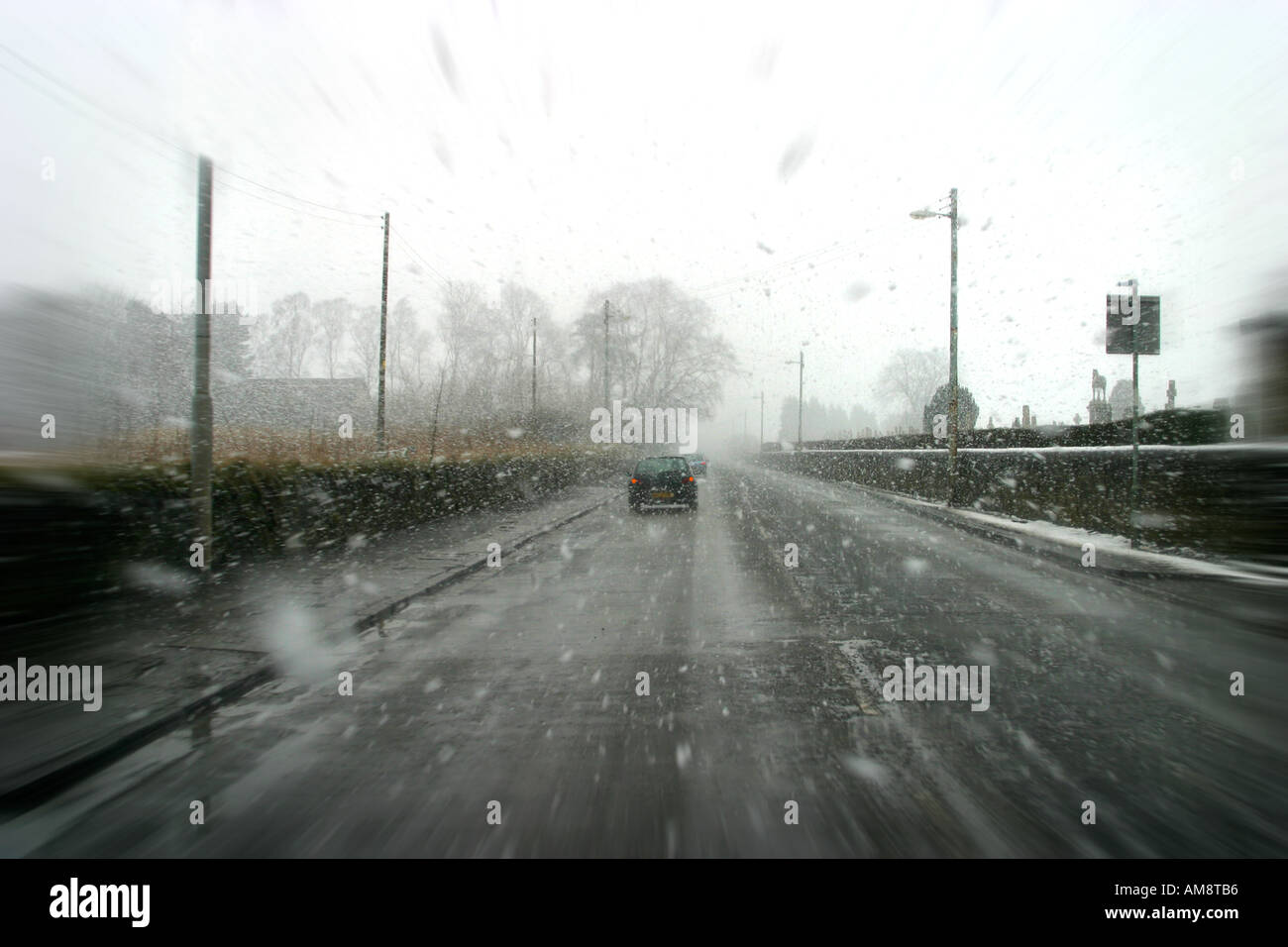 Urban road from in car with driving sleet and snow Stock Photo
