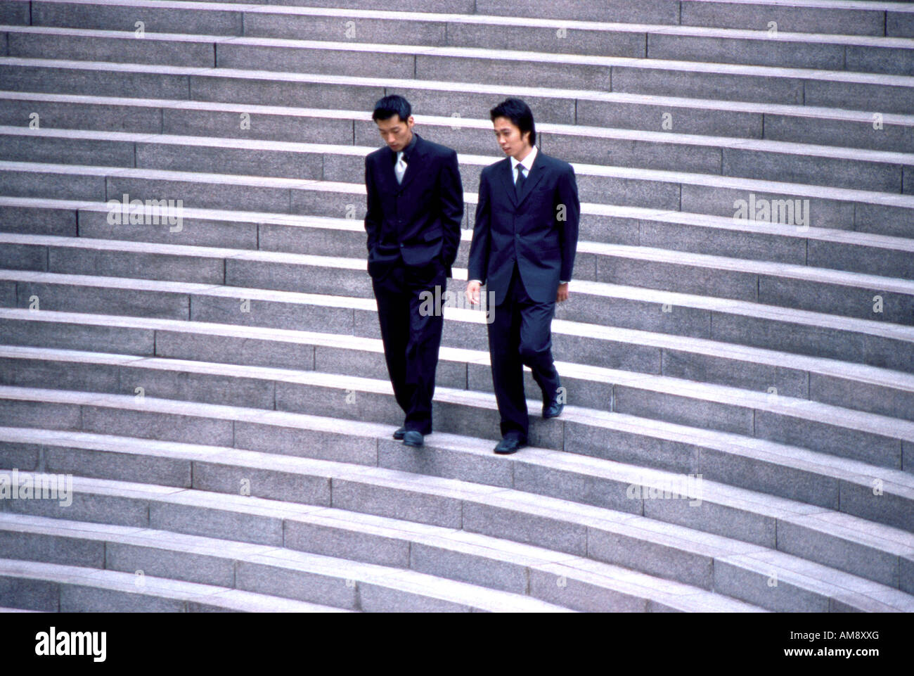 Two Businessmen Walking Down Stairs Stock Photo - Alamy