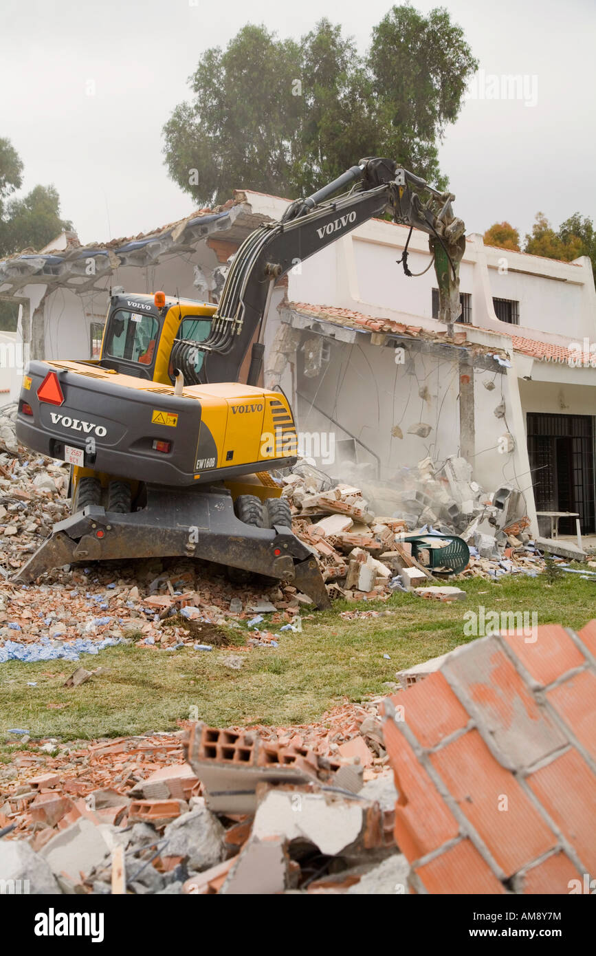 Demolition of old buildings with aid of mechanical excavator Stock Photo