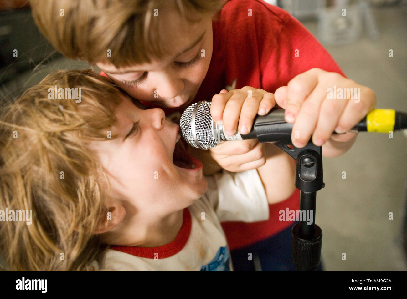children singing into microphone closeup Stock Photo