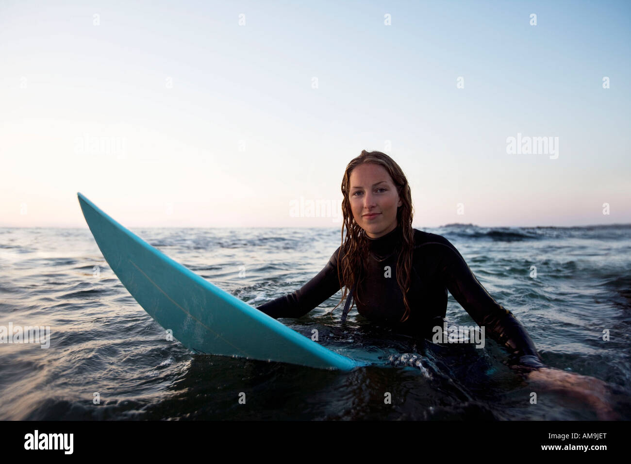 Woman Sitting On Surfboard In The Water Stock Photo Woman Sitting On Surfboard In The Water Stock Photo