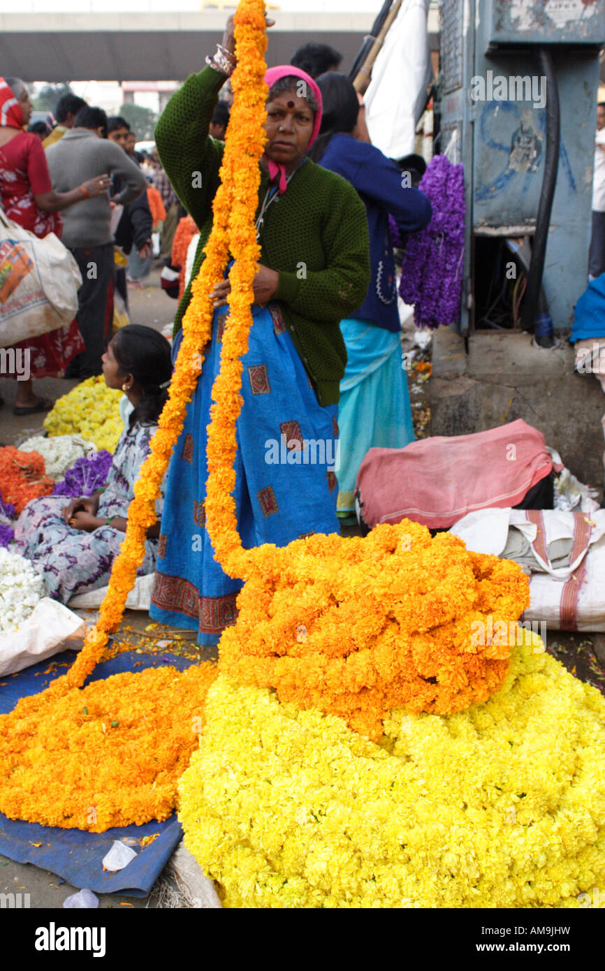A woman sells flowers at a street market in Bangalore, one of the ...