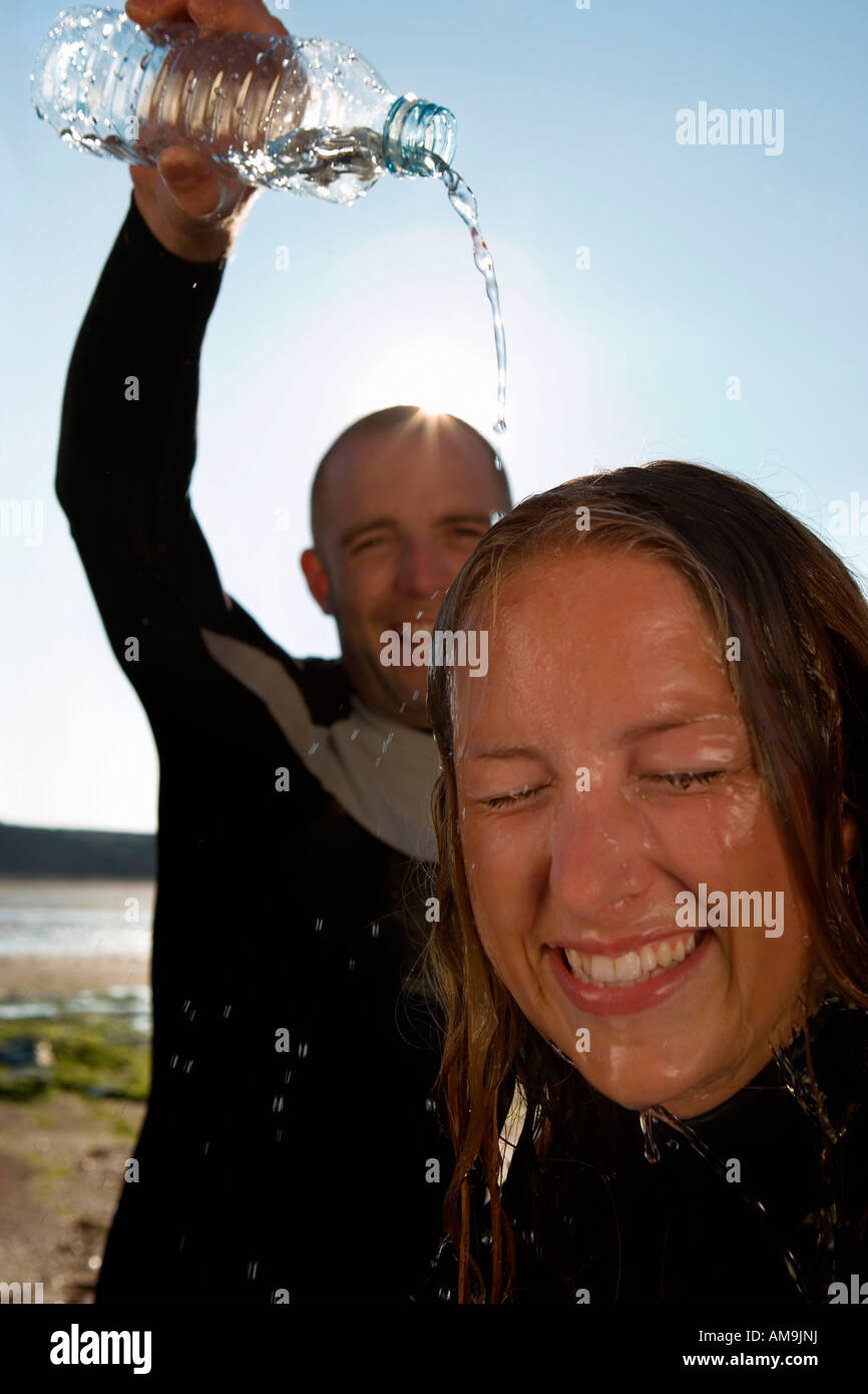 Laughing man pouring water over woman's head Stock Photo Alamy