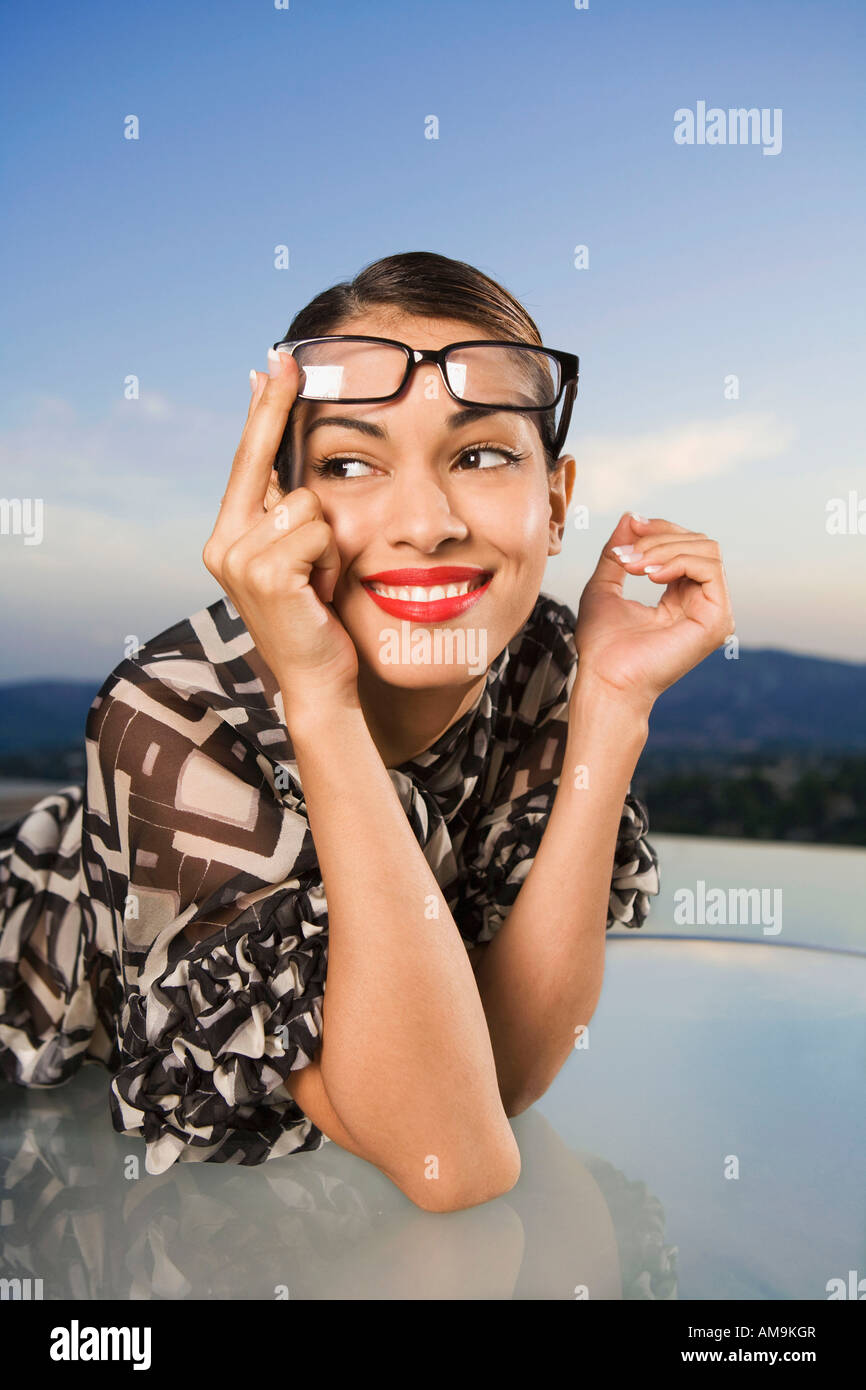 Woman pushing eyeglasses up onto head smiling outdoors Stock Photo - Alamy